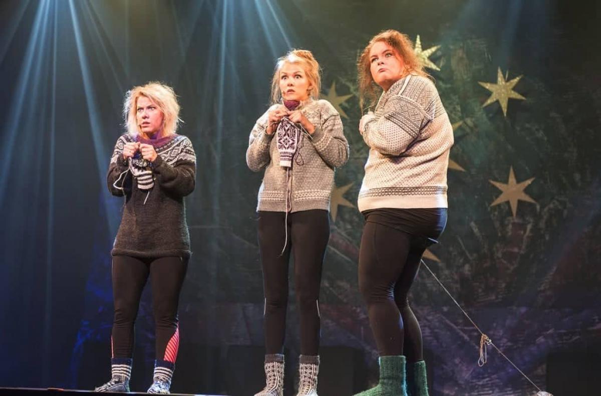 Tre damer på scena som strikker